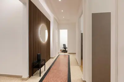 a hallway with two black chairs and a round window at Lifestyle Vatican Apartment in Rome