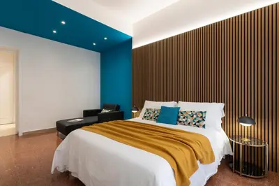 a bedroom with a large bed and a blue wall at Lifestyle Vatican Apartment in Rome