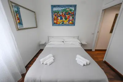 a white bed in a room with two white towels at Casa Angelico in Rome