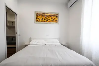 a bed in a white room with a painting on the wall at Casa Angelico in Rome