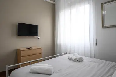 a bedroom with a bed with towels and a tv at Casa Angelico in Rome