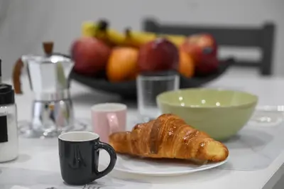 a plate with a croissant on a table with fruit at Casa Angelico in Rome