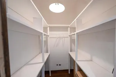 a dressing room with white shelves and a door at Casa Angelico in Rome