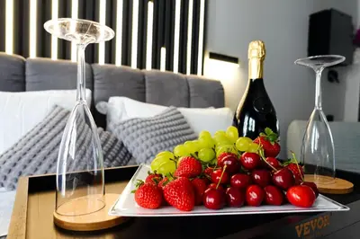 a plate of strawberries and grapes on a table with wine glasses at HeySuite - Luxury House - ROMA Trastevere in Rome