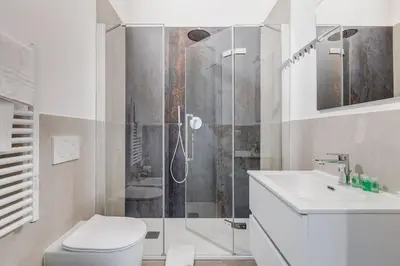 a bathroom with a shower and a toilet and a sink at Inner House 3 in Rome