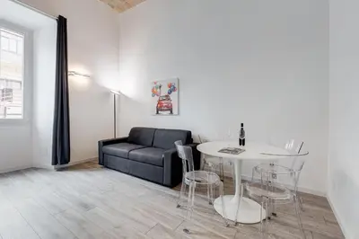 a living room with a black couch and a table at Inner House 3 in Rome