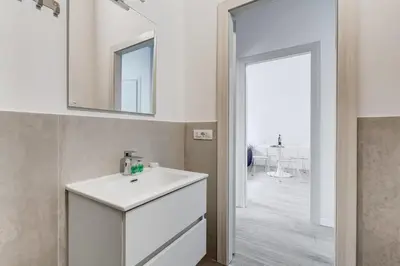 a white bathroom with a sink and a mirror at Inner House 3 in Rome