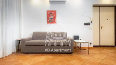 a couch in a living room with a picture of the colossus at Vatican-Balduina Apartment in Rome