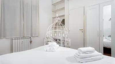 a white room with a bed with towels on it at Vatican-Balduina Apartment in Rome