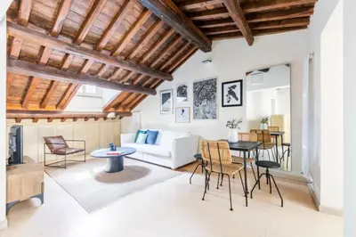 a living room with wooden ceilings and a table and chairs at Balestrari Boutique Apartment in Rome