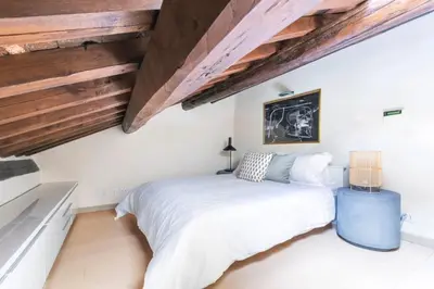 a bedroom with a large bed and wooden ceilings at Balestrari Boutique Apartment in Rome