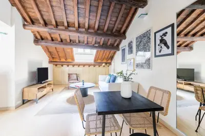 a living room with wooden ceilings and a table and chairs at Balestrari Boutique Apartment in Rome
