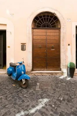 a blue scooter parked in front of a building at Balestrari Boutique Apartment in Rome