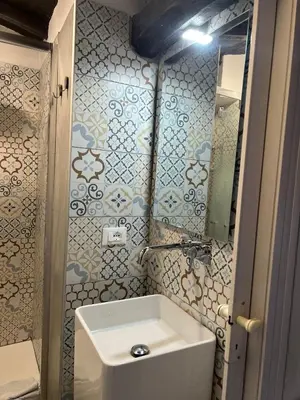 a bathroom with a white sink and a mirror at Monolocale Trastevere locato per finalità turistiche in Rome
