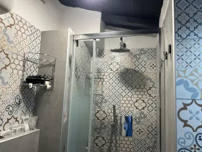 a shower with a glass door in a bathroom at Monolocale Trastevere locato per finalità turistiche in Rome