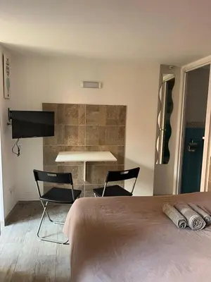 a bedroom with a bed and two chairs and a table at Monolocale Trastevere locato per finalità turistiche in Rome