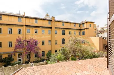 a large yellow building with trees in front of it at Rome as you feel - Luxury Cappellari Apartment in Rome