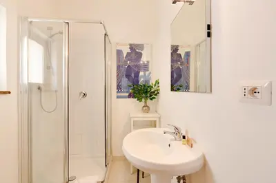 a white bathroom with a sink and a shower at Rome as you feel - Luxury Cappellari Apartment in Rome