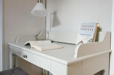 a white desk with a book and a lamp at Gelso in Rome