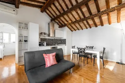 a living room with a black couch and a table at Pavone Centre Romantic Apartment in Rome