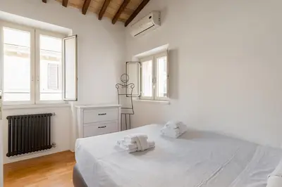a white bedroom with a bed with towels on it at Pavone Centre Romantic Apartment in Rome