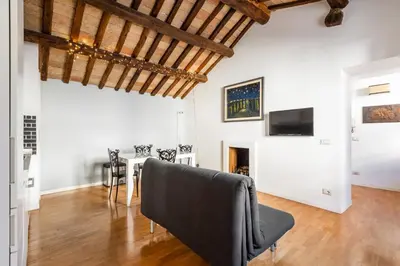 a living room with white walls and wooden ceilings at Pavone Centre Romantic Apartment in Rome