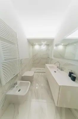 a white bathroom with a sink and a toilet at Banchi Nuovi, modern and cozy apartment in Rome