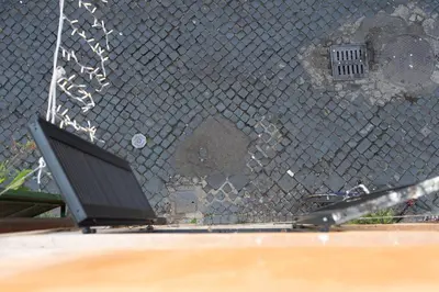a chain link fence with a laptop on a table at Banchi Nuovi, modern and cozy apartment in Rome