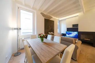 a dining room with a wooden table and chairs at Banchi Nuovi, modern and cozy apartment in Rome