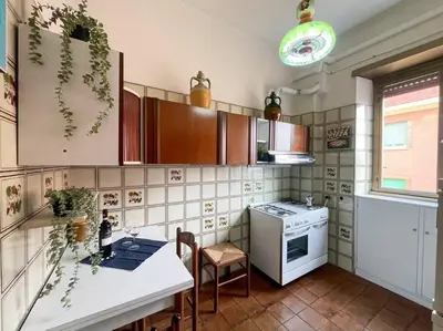 a kitchen with a table and a stove top oven at Da Bricca a Monteverde in Rome