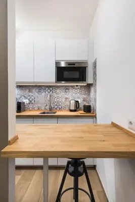 a kitchen with a wooden table and a microwave at Super Comfort Pisino Street in Rome