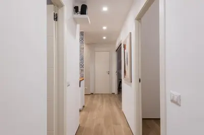 a hallway with white walls and wooden floors at Super Comfort Pisino Street in Rome