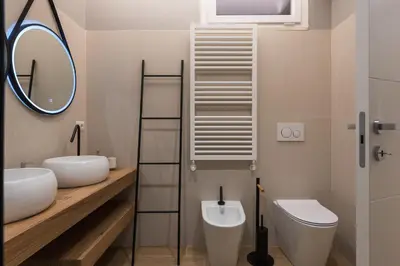 a bathroom with two sinks and a toilet and a mirror at Super Comfort Pisino Street in Rome