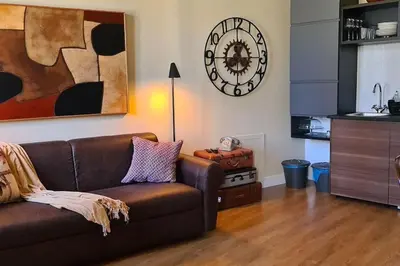 a living room with a couch and a clock on the wall at CAMERA con VISTA in Rome