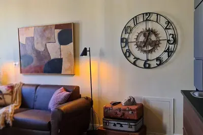 a living room with a couch and a clock on the wall at CAMERA con VISTA in Rome