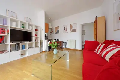 a living room with a red couch and a glass table at Metastasio in Rome