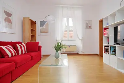 a living room with a red couch and a glass table at Metastasio in Rome