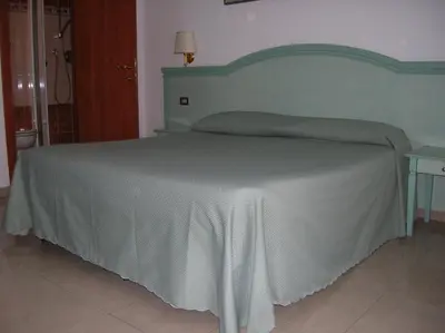 a bedroom with a bed with a green headboard at Chiara Stella Guest House in Rome