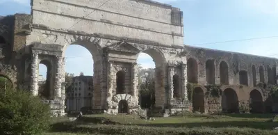 an old stone building with arches in a field at Chiara Stella Guest House in Rome