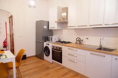 a kitchen with a refrigerator and a sink and a dishwasher at Angelina's cozy home in Rome