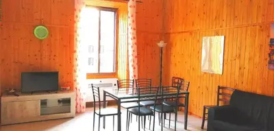 a dining room with a table and chairs and a television at Rome Near Colosseum in Rome