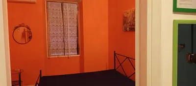 a room with an orange wall and a window at Rome Near Colosseum in Rome
