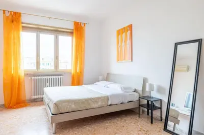 a bedroom with a large bed and a mirror at Ambra's bright apartment in Rome