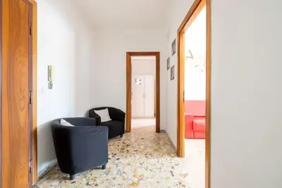 a living room with a black chair and a mirror at Ambra's bright apartment in Rome