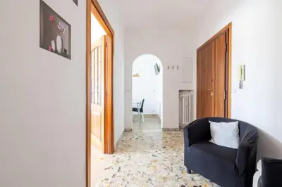 a living room with a blue chair and a mirror at Ambra's bright apartment in Rome