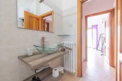 a bathroom with a glass bowl sink on a counter at Ambra's bright apartment in Rome