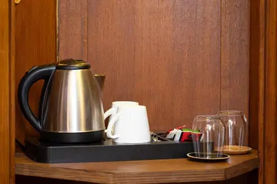 a tea kettle and cups on a wooden shelf at TimeRoma Suites in Rome