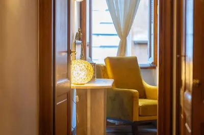 a living room with a yellow chair and a table at TimeRoma Suites in Rome