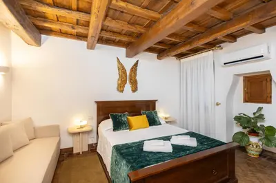 a bedroom with a bed and a couch at TimeRoma Suites in Rome