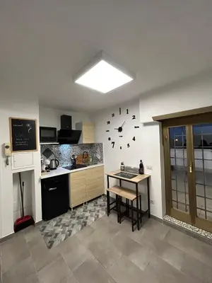 a kitchen with a table and a clock on the wall at La Terrazza di Attila in Rome